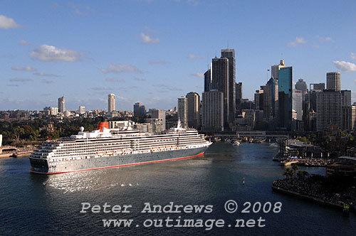 Queen Victoria slips astern out of Circular Quay with the Sydney city skyline in the background.