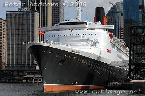 Queen Elizabeth 2 alongside at the Overseas Passenger Terminal, Circular Quay Sydney with the city skyline in the background.